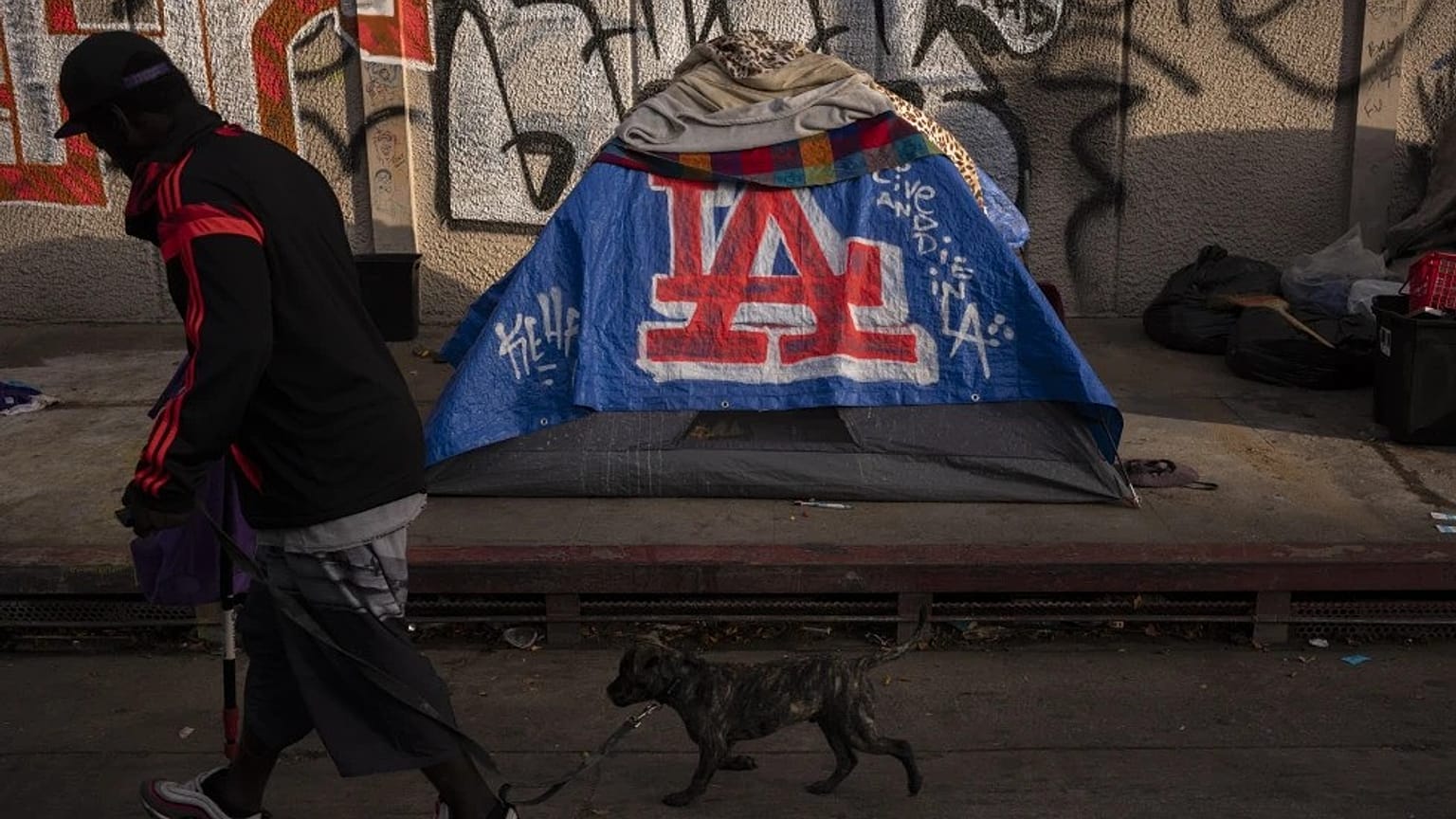 ABD'de bir adam, 25 Ekim 2023 Çarşamba günü Los Angeles şehir merkezindeki bir çadırın önünden geçiyor.