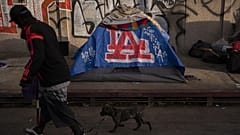 ABD'de bir adam, 25 Ekim 2023 Çarşamba günü Los Angeles şehir merkezindeki bir çadırın önünden geçiyor.