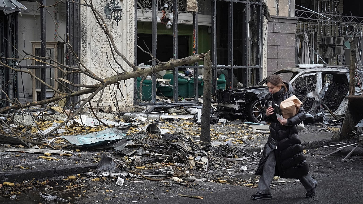 Una mujer camina junto a los edificios destruidos por los recientes ataques rusos en Kiev, 20 de diciembre de 2024.