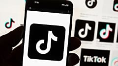 Le logo TikTok est affiché sur un téléphone portable devant un écran d'ordinateur qui affiche la page d'accueil de TikTok à Boston, le 7 mai 2024.