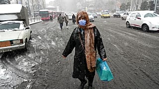 عکس تزیینی است؛  زنی در زمستان ایران در میدان تجریش تهران، ژانویه ۲۰۲۳