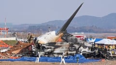 Des pompiers et des membres de l'équipe de sauvetage enquêtent près de l'épave d'un avion de ligne à l'aéroport international de Muan à Muan, en Corée du Sud, le 29.12.2024