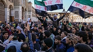 أشخاص يهتفون ويلوحون بالعلم السوري الجديد أثناء تجمعهم للصلاة يوم الجمعة في المسجد الأموي في دمشق بسوريا 13 كانون الأول ديسمبر 2024