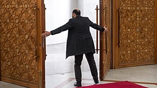 أحد العمال يفتح أبواب القصر الرئاسي قبل لقاء الزعيم الفعلي لسوريا أحمد الشرع المعروف سابقاً باسم أبو محمد الجولاني مع وزير الدولة الليبي للاتصالات والشؤون السياسية وليد اللافي