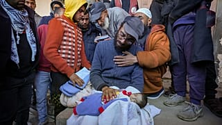 Yehia al-Batran segura o corpo do seu filho Jomaa, de 20 dias, que morreu de hipotermia em Gaza, 29 de dezembro de 2024