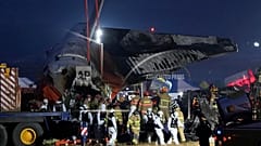 Zespół ratunkowy niesie ciało pasażera po śmiertelnym wypadku na międzynarodowym lotnisku w Muan