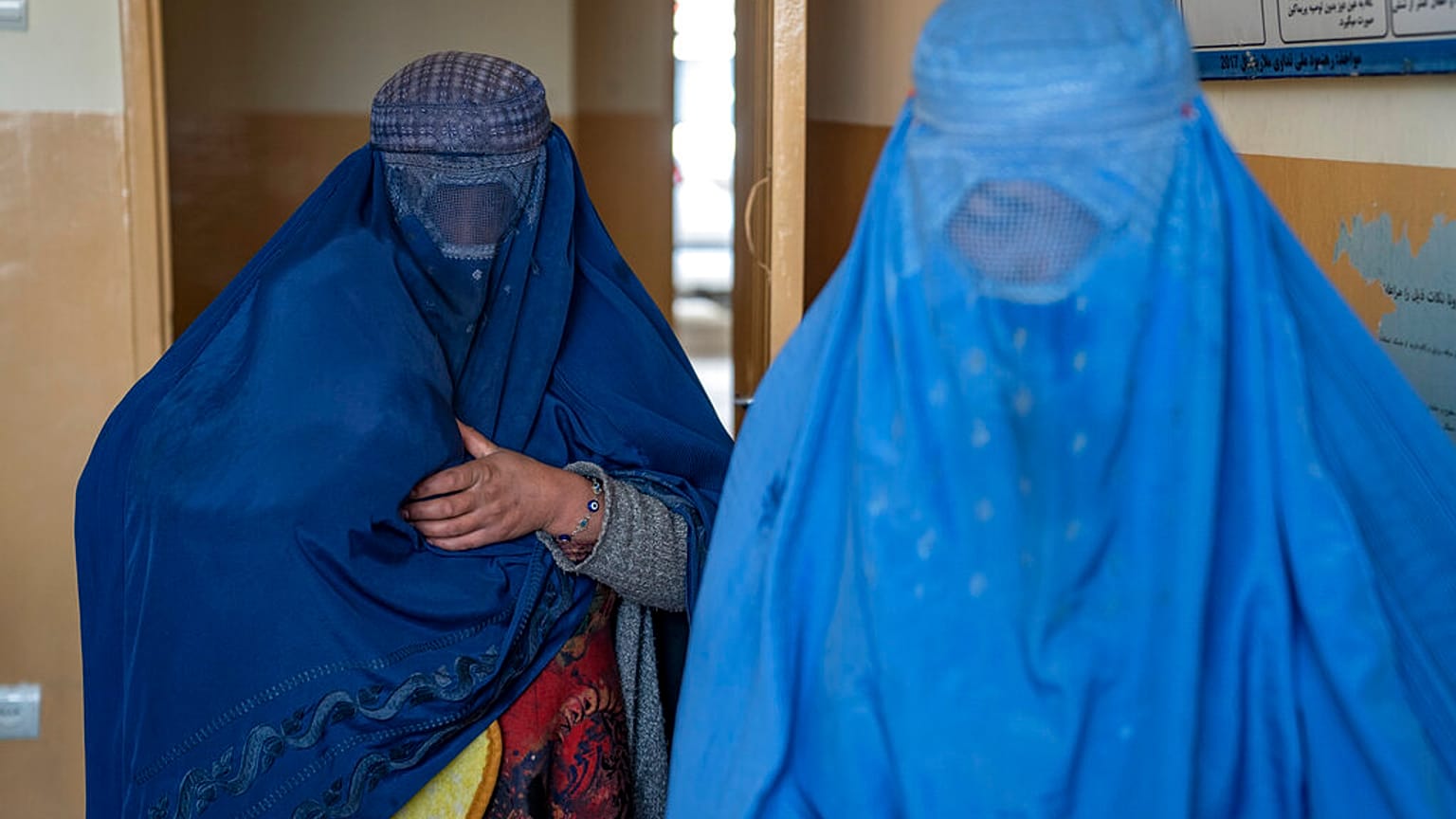 Afganas se cubren con un burka, la prenda islámica instaurada por los talibanes para todas las mujeres