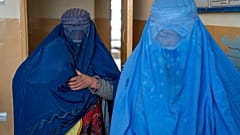 Afganas se cubren con un burka, la prenda islámica instaurada por los talibanes para todas las mujeres