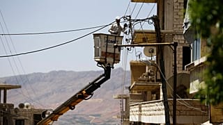 عامل كهرباء سوري يقوم بإصلاح كابلات الكهرباء في بلدة مضايا في ريف دمشق، سوريا. 