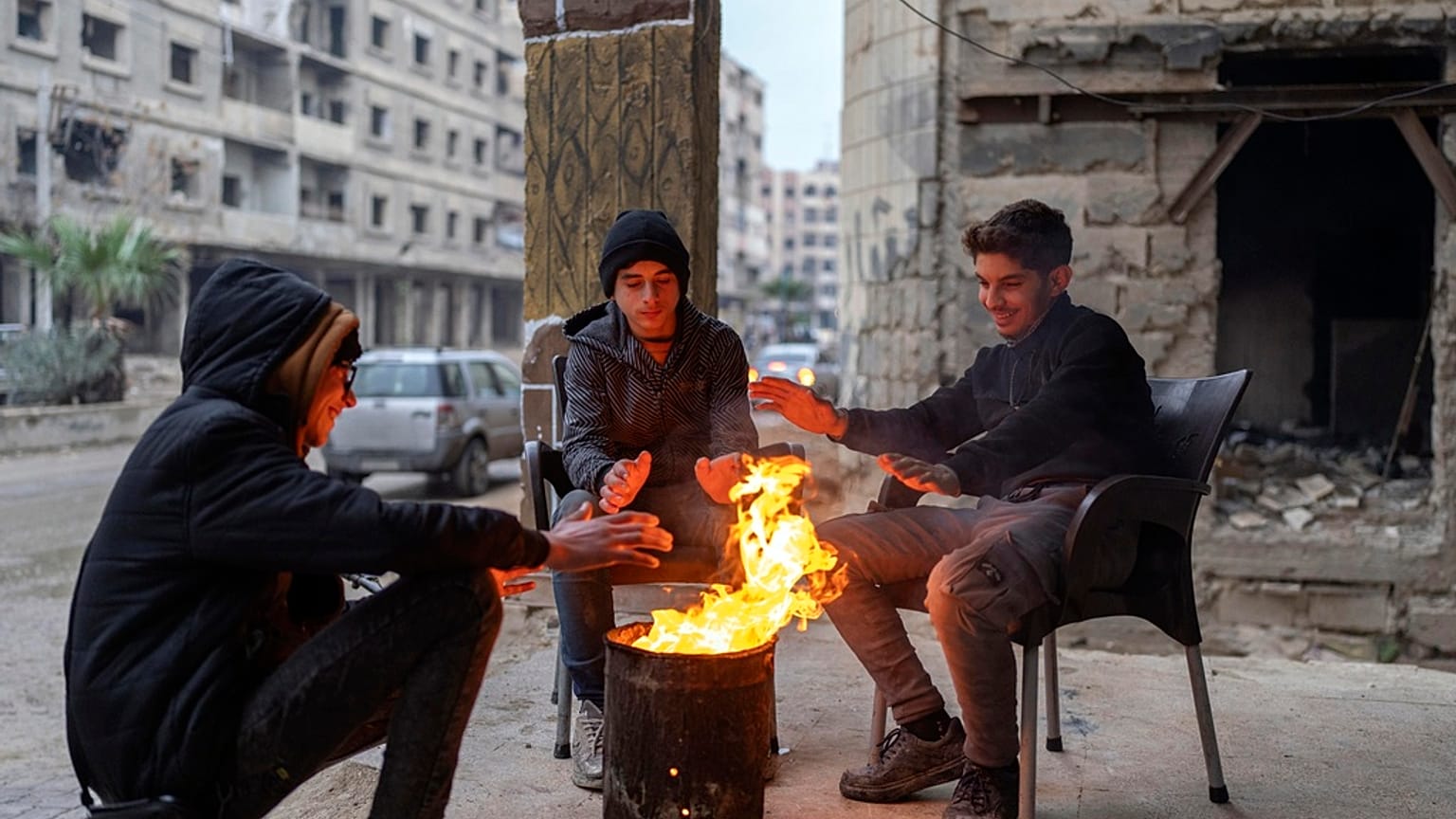 Suriye'nin başkenti Şam'da bir grup genç, bir tenekede yaktıkları ateşle ısınmaya çalışıyor, 29 Aralık 2024