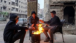 Suriye'nin başkenti Şam'da bir grup genç, bir tenekede yaktıkları ateşle ısınmaya çalışıyor, 29 Aralık 2024