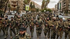 عناصر من القوات المسلحة الجديدة يخدمون الآن في الحكومة السورية الجديدة خلال عرض عسكري في وسط دمشق