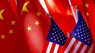 Bandeiras americanas são exibidas com bandeiras chinesas no topo de um trishaw em 16 de setembro de 2018, em Pequim.