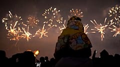 Un enfant sur les épaules de son père admire le feu d'artifice du nouvel an à Liuyang en Chine le 28.12.2024