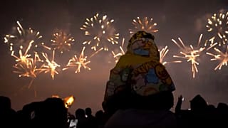 Ein Kind auf den Schultern seines Vaters bewundert am 28.12.2024 das Neujahrsfeuerwerk in Liuyang in China.