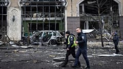 Policjanci przechodzą obok budynków zniszczonych w wyniku niedawnych rosyjskich ataków w Kijowie, Ukraina, piątek, 20 grudnia 2024 r.