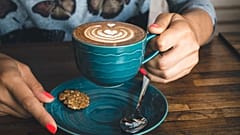 Una persona con una taza de café en la mano. 