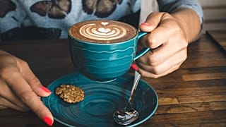 Una persona con una taza de café en la mano. 