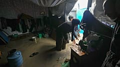 منال لباد نازحة من مدينة غزة تحاول تنظيف خيمتها التي غمرتها المياه بعد هطول أمطار غزيرة في دير البلح وسط قطاع غزة، الثلاثاء 31 ديسمبر/كانون الأول 2024