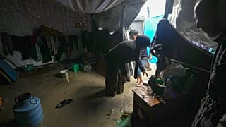 منال لباد نازحة من مدينة غزة تحاول تنظيف خيمتها التي غمرتها المياه بعد هطول أمطار غزيرة في دير البلح وسط قطاع غزة، الثلاثاء 31 ديسمبر/كانون الأول 2024