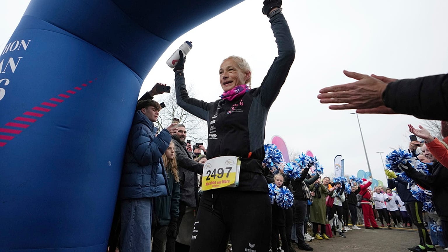 A ultra-corredora belga Hilde Dosogne, ao centro, é aplaudida ao cruzar a linha de chegada durante sua 366ª maratona consecutiva em Ghent, Bélgica, terça-feira, 31 de dezembro de 2024