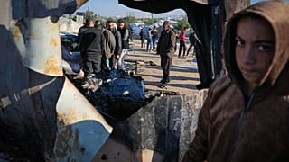 فلسطينيون يتفقدون موقع غارة للجيش الإسرائيلي في منطقة المواصي، في خان يونس، وسط قطاع غزة، الخميس 2 يناير/كانون الثاني 2025