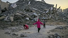 Палестинские дети играют рядом со зданием, разрушенным в результате ударов израильской армии в Хан-Юнесе, сектор Газа, 1 января 2025 года.