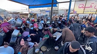Des foules agitent des casseroles au-dessus de leur tête pour obtenir de l'aide alimentaire à Khan Younis.