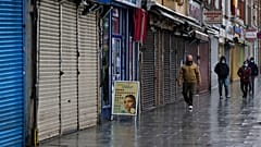 أشخاص يمرون بالقرب من متاجر مغلقة في لندن