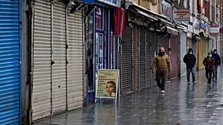 أشخاص يمرون بالقرب من متاجر مغلقة في لندن
