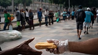 Homeless people gather for coffee and bread in Rio de Janeiro, Brazil, in March 2020.