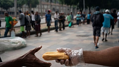 Homeless people gather for coffee and bread in Rio de Janeiro, Brazil, in March 2020.