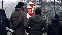 Archivo: Migrantes cerca de la valla de alambre de púas con un pilar fronterizo polaco mientras se reúnen en la frontera entre Bielorrusia y Polonia cerca de Grodno.