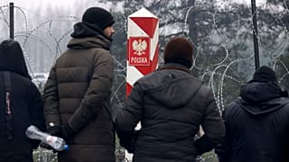 Archivo: Migrantes cerca de la valla de alambre de púas con un pilar fronterizo polaco mientras se reúnen en la frontera entre Bielorrusia y Polonia cerca de Grodno.