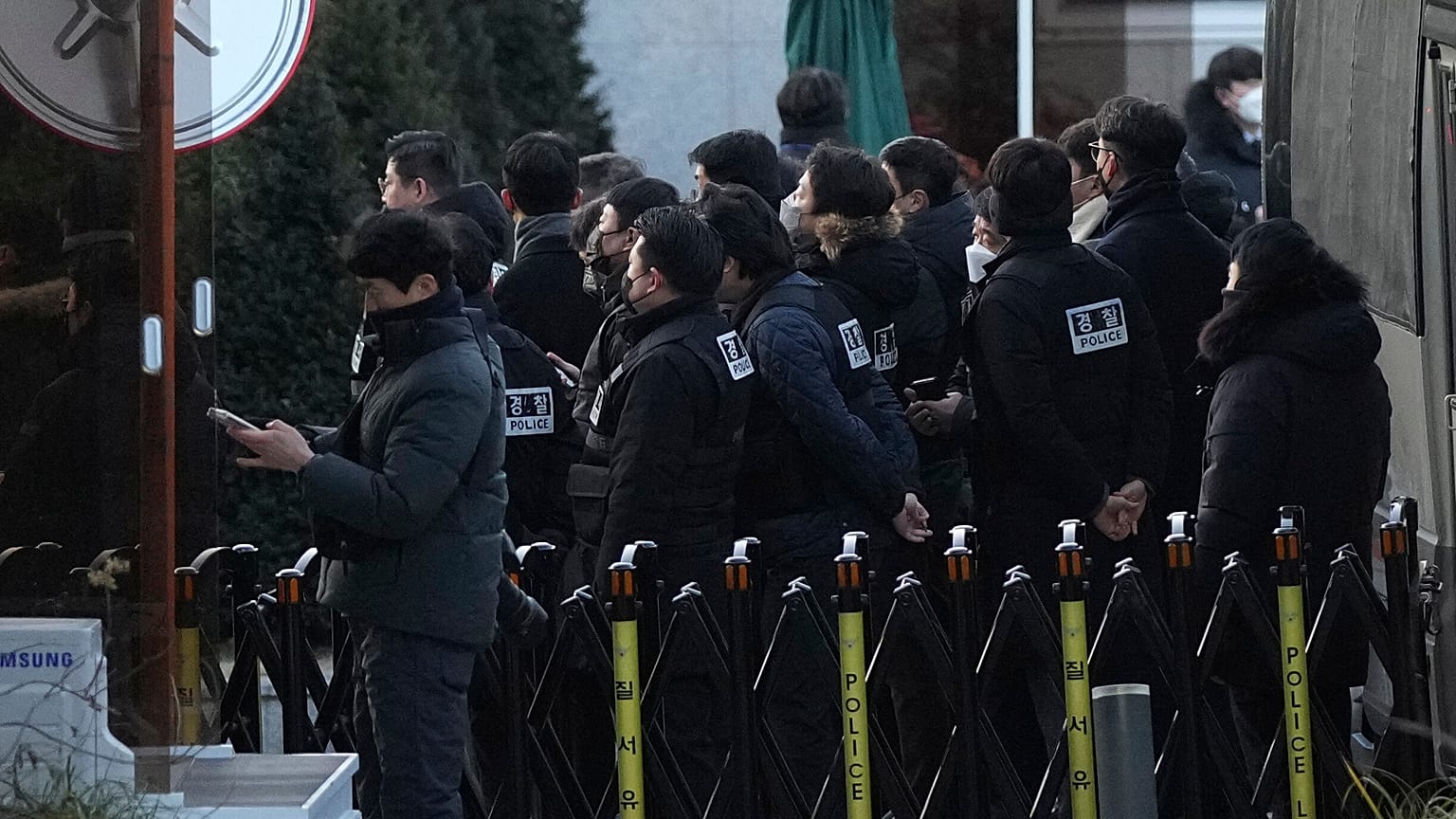 Des policiers arrivent à la porte de la résidence présidentielle à Séoul avec un mandat d'arrêt contre le président Yoon Suk Yeol, 3 janvier 2025.