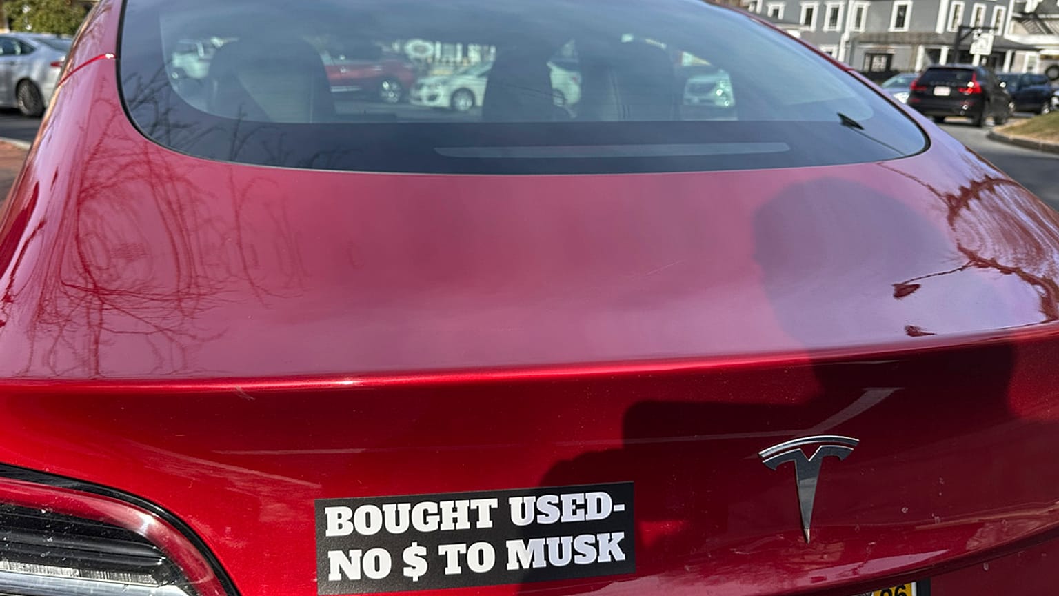 Vehículo tesla con el letrero: "Comprado usado, no dólares para Musk". 