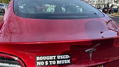 Vehículo tesla con el letrero: "Comprado usado, no dólares para Musk". 