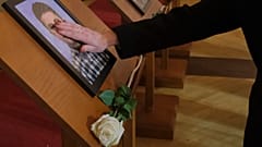 Menschen mit Fotos von Angehörigen bei der Gedenkfeier für die 12 Opfer der Schießerei in Cetinje, 4. Januar 2025
