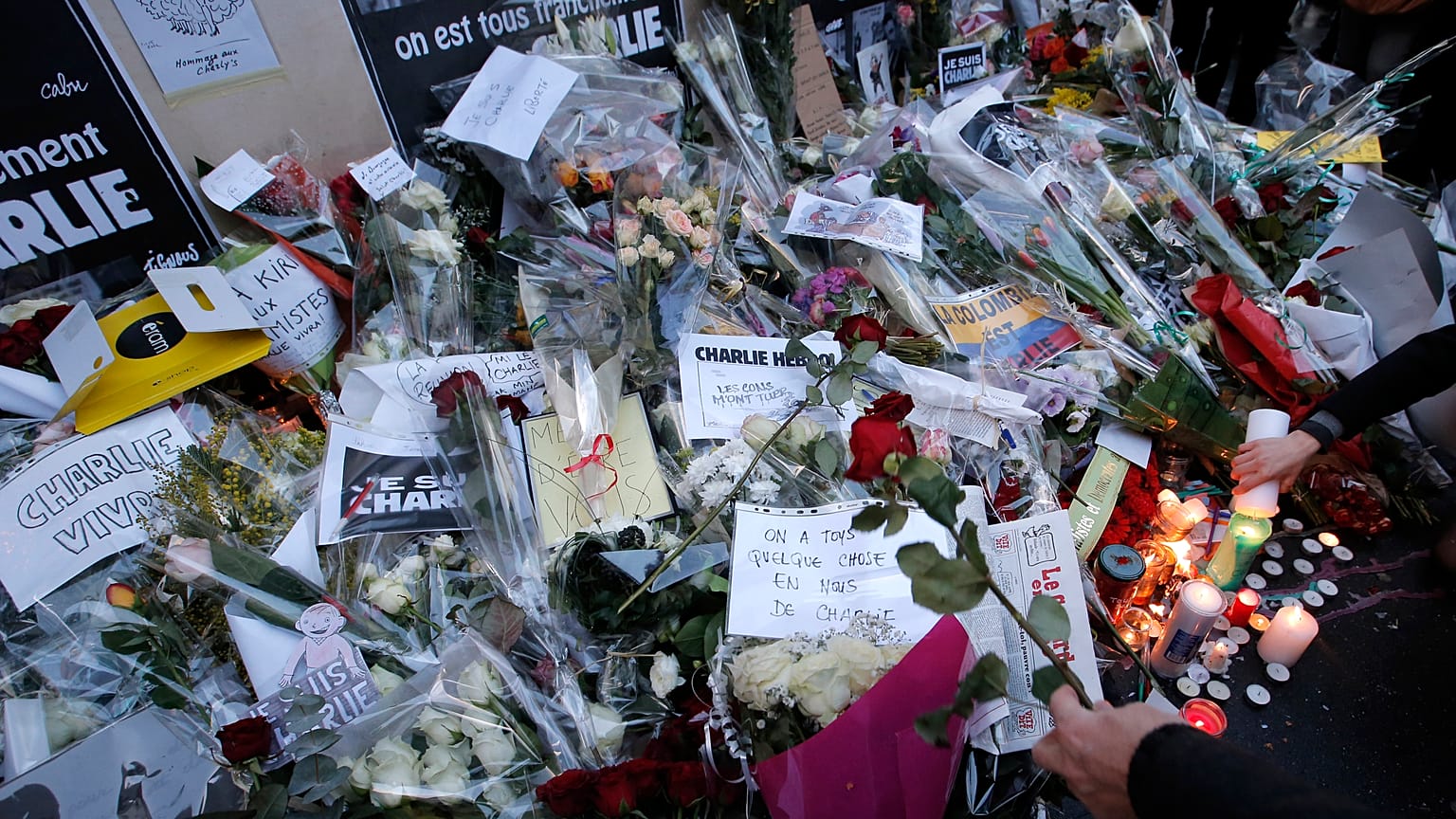 Fiori e candele sono stati deposti davanti agli uffici del giornale Charlie Hebdo a Parigi giovedì 8 gennaio 2015.