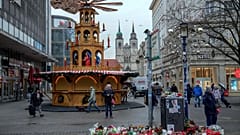 Menschen laufen über den Weihnachtsmarkt in Magdeburg, wo am Freitagabend ein Auto in eine Menschenmenge fuhr, Montag, 23. Dezember 2024.