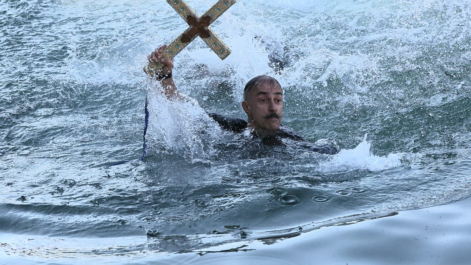 	Μέλη του Συνδέσμου Ελλήνων Βατραχανθρώπων βουτάνε στη θάλασσα για να πιάσουν το Σταυρό, στον εορτασμό των Θεοφανείων με τον καθαγιασμό των υδάτων στο λιμάνι του Πειραιά