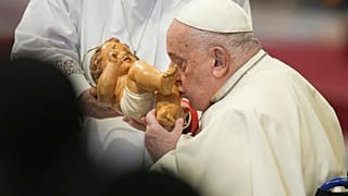 Pope Francis kisses the baby Jesus as he presides over an Epiphany mass in St.Peter's Basilica, at the Vatican on 6 January 2025.