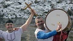 Uma búlgara canta e dança e segura uma cruz de madeira no rio Lesnovska durante as celebrações do Dia da Epifania na cidade de Elin Pelin, Bulgária, segunda-feira, 6 de janeiro de 2025.