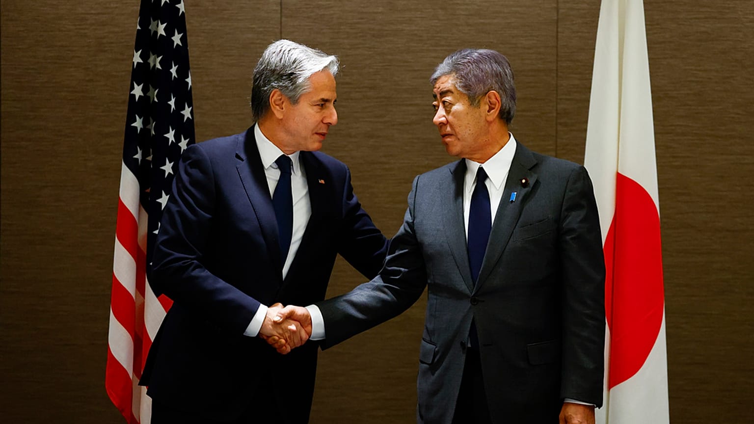 Antony Blinken amerikai külügyminiszter (balra) kezet fog Takeshi Iwaya japán külügyminiszterrel, miközben munkaebédet tart vele egy tokiói szállodában.