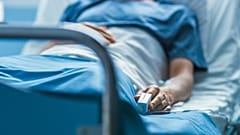 Ein Patient liegt in einem Krankenhausbett.