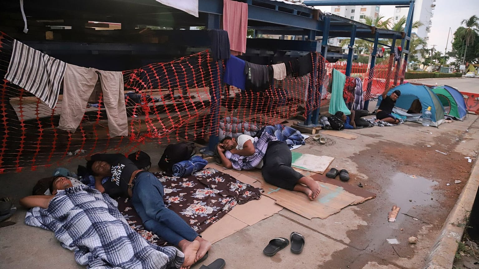 Migrantes dormem na berma de uma rua em Acapulco, México, segunda-feira, 6 de janeiro de 2025.