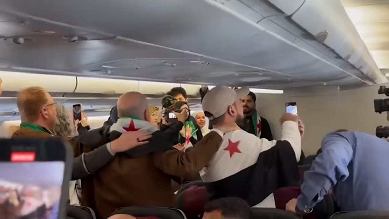 I passeggeri siriani cantano a bordo del primo volo Qatar Airways per Damasco dopo la partenza di Assad