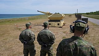 Slovak askerler Mantis (Modüler, Otomatik ve Ağ Yetenekli Hedefleme ve Önleme Sistemi) hava savunma silah sisteminin bir silahının yanında duruyor.