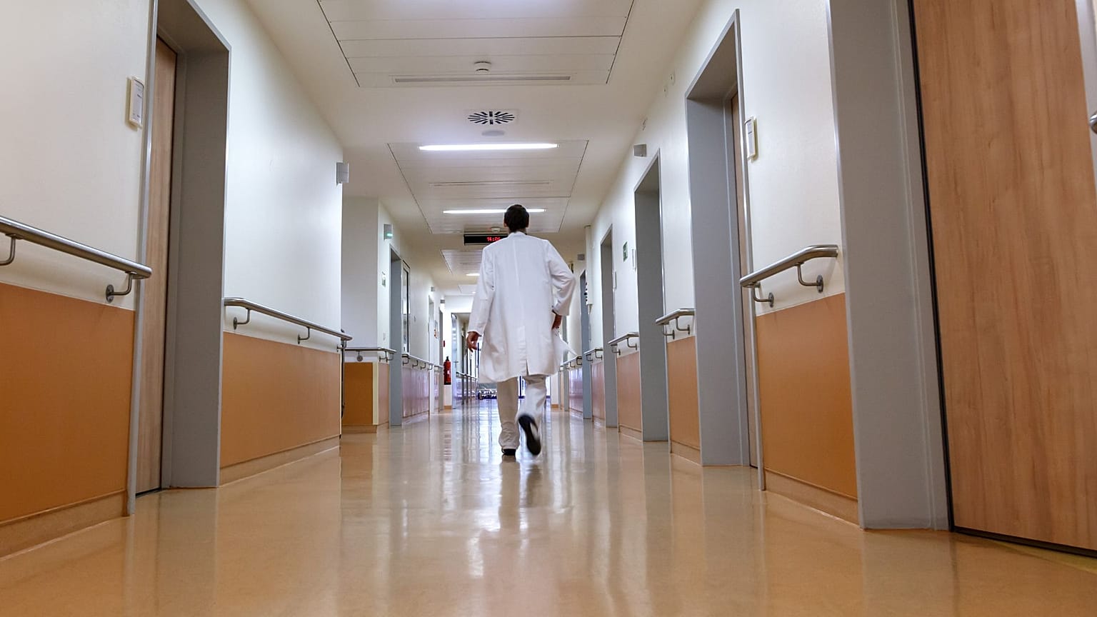 Bir doktor koridorda yürüyor.