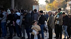 Des habitants font la queue pour acheter du pain dans une boulangerie à Alep, en Syrie, le samedi 14 décembre 2024.